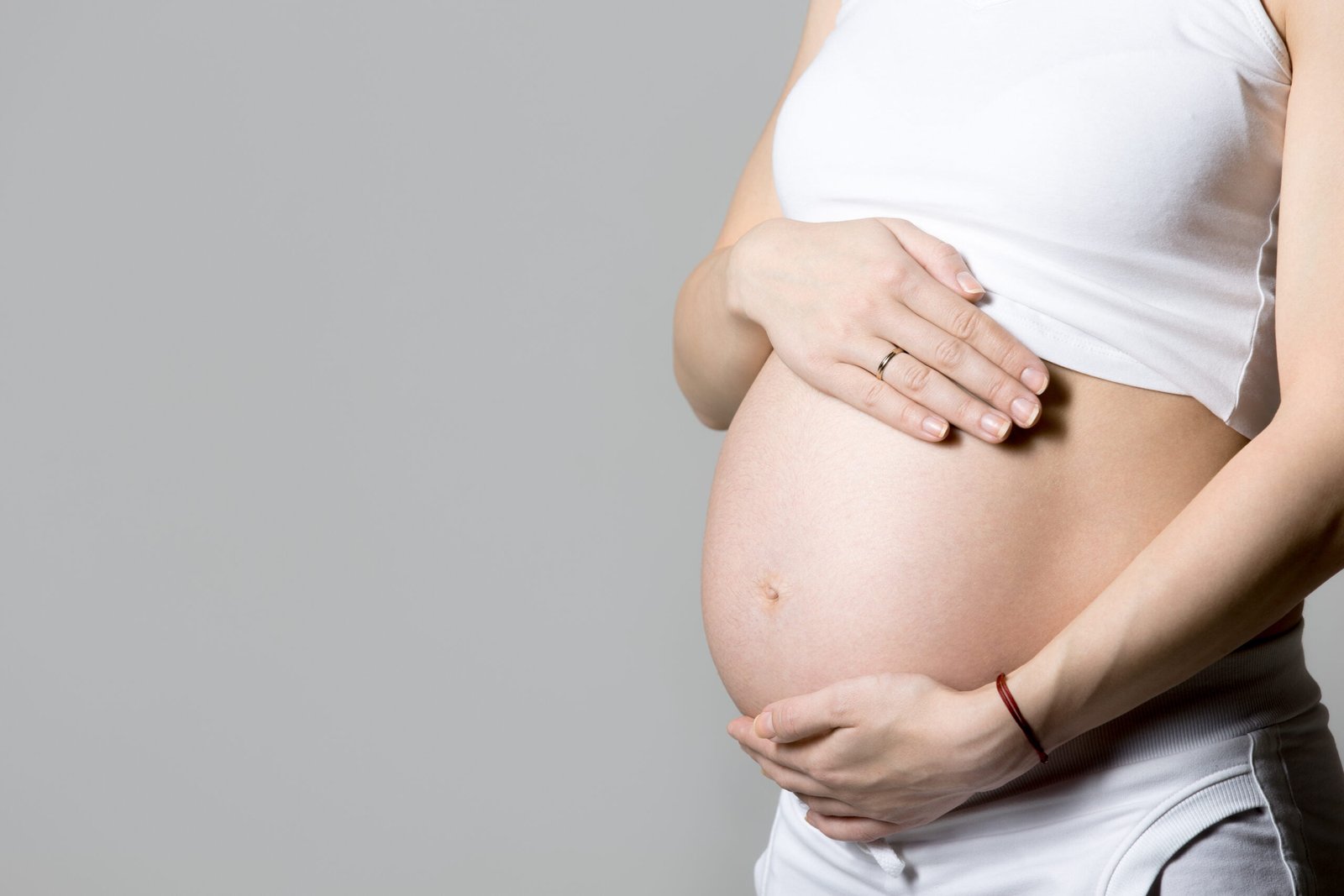 pregnant woman touching her belly scaled